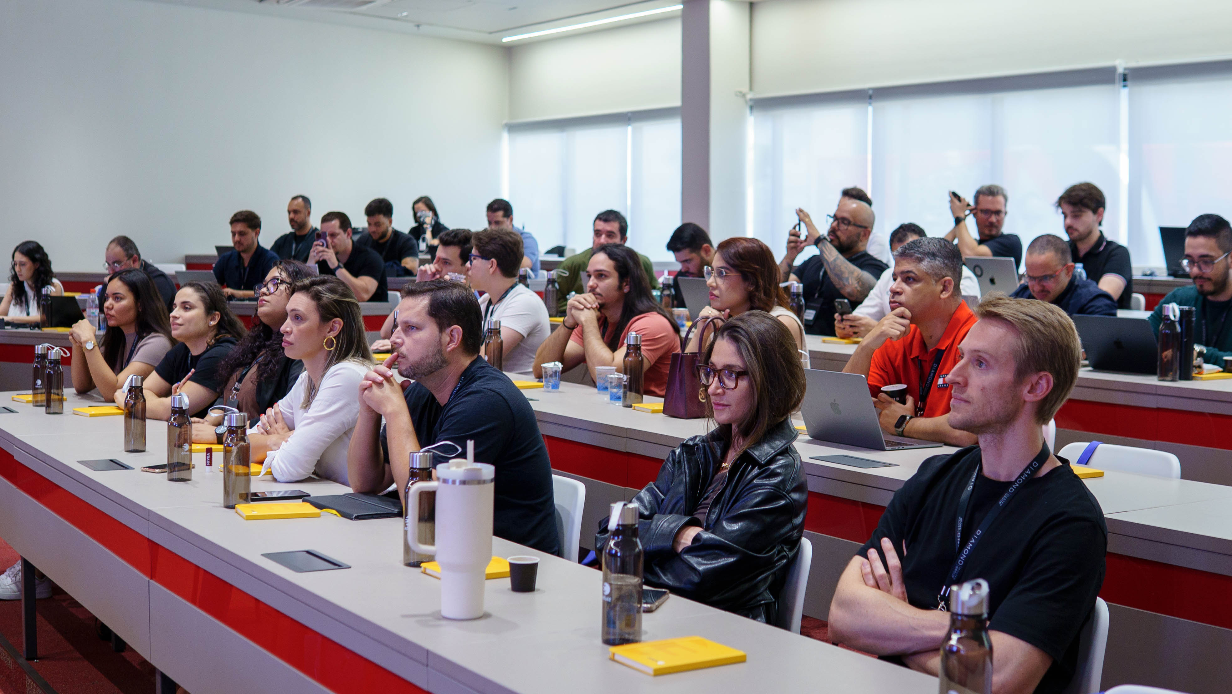 Participantes assistindo apresentação no evento